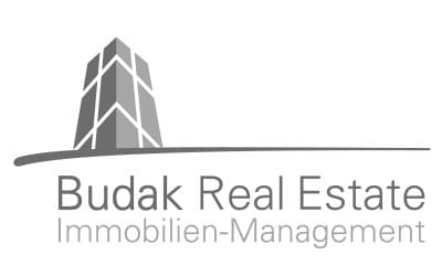 Logo für Budak Real Estate Immobilien-Management mit einer stilisierten Gebäudegrafik über dem Firmennamen in grauer Schrift.