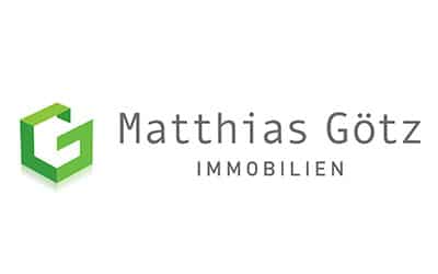 Logo für Matthias Götz Immobilien mit einem grünen geometrischen „G“-Symbol auf der linken Seite und dem Firmennamen in grauer Schrift auf der rechten Seite.