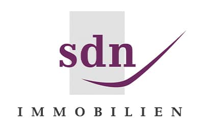 Logo mit dem Text „sdn“ in Lila über einem grauen Rechteck, darunter ein lila Swoosh und darunter „IMMOBILIEN“ in schwarzen Großbuchstaben.